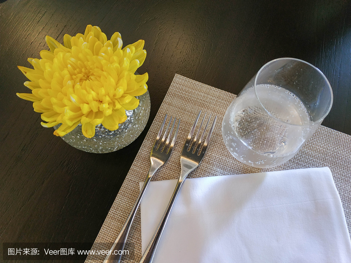 顶视图装饰桌子与水晶玻璃,亚麻餐巾,叉子和黄色的花
